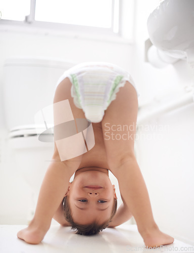 Image of Toddler, boy and bathroom with diaper, happy and playful for child development, potty training and kid. Learning, body and upside down with growth, playing and bums for fun, young and toilet