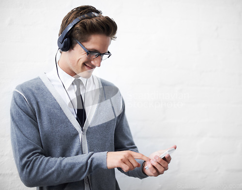 Image of Man, headphones and listening to audio and phone for music by wall background, sound and peace. Male person, smartphone and streaming radio or podcast, online and hearing song and mobile application