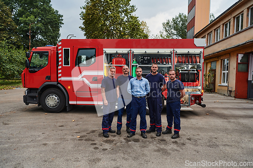 Image of A skilled and dedicated professional firefighting team proudly poses in front of their state of the art firetruck, showcasing their modern equipment and commitment to ensuring public safety.
