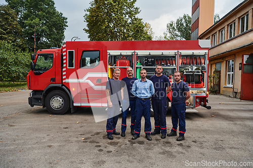 Image of A skilled and dedicated professional firefighting team proudly poses in front of their state of the art firetruck, showcasing their modern equipment and commitment to ensuring public safety.