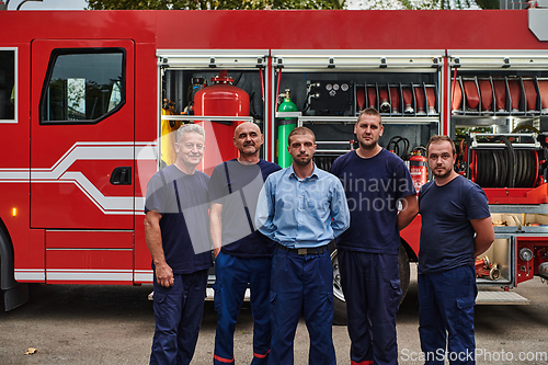 Image of A skilled and dedicated professional firefighting team proudly poses in front of their state of the art firetruck, showcasing their modern equipment and commitment to ensuring public safety.