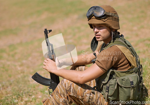 Image of Military, thinking and man with gun in nature for war, conflict and patriotism. Army warrior, surveillance and security with person relax on grass in outdoors for soldier, battlefield and veteran