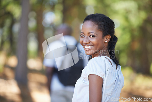 Image of Portrait, smile and black woman hiking in the forest together with her husband for travel, freedom or adventure. Face, nature or environment with a young hiker in the woods or wilderness for vacation