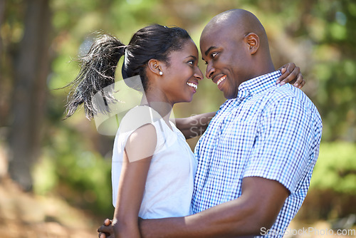 Image of Hug, love or happy black couple in nature to relax or bond on holiday vacation together to travel. Romantic, eye contact or African woman with smile, care or man in woods on outdoor forest adventure