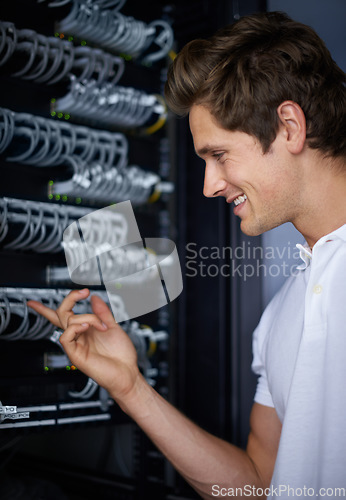 Image of Server room, man and check cables with smile, thinking and connectivity with hardware in night. Cybersecurity system, it network and technician for glitch, data center and problem solving for error
