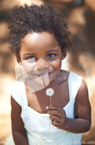 Image of Happy, black child and portrait in nature, flower and summer holiday with sunshine in forest. Young, african toddler and smile face for dandelion on vacation, spring and countryside in relax wellness