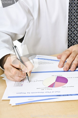 Image of Office worker writing on reports