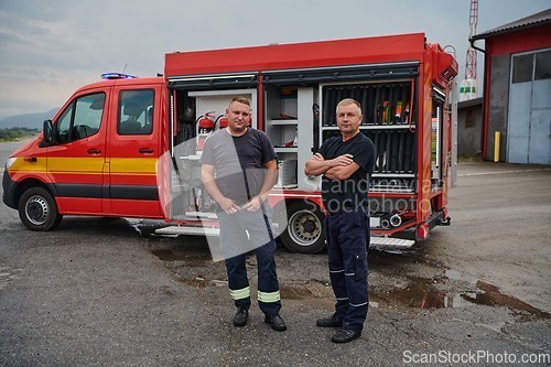 Image of A skilled and dedicated professional firefighting team proudly poses in front of their state of the art firetruck, showcasing their modern equipment and commitment to ensuring public safety.