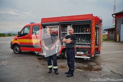 Image of A skilled and dedicated professional firefighting team proudly poses in front of their state of the art firetruck, showcasing their modern equipment and commitment to ensuring public safety.
