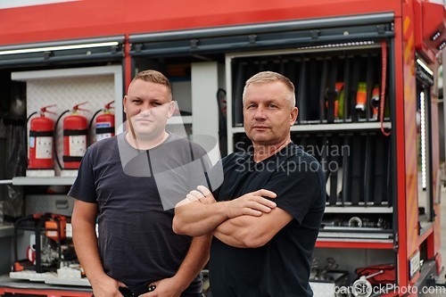 Image of A skilled and dedicated professional firefighting team proudly poses in front of their state of the art firetruck, showcasing their modern equipment and commitment to ensuring public safety.
