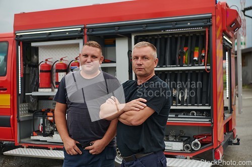 Image of A skilled and dedicated professional firefighting team proudly poses in front of their state of the art firetruck, showcasing their modern equipment and commitment to ensuring public safety.