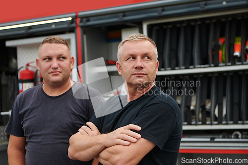 Image of A skilled and dedicated professional firefighting team proudly poses in front of their state of the art firetruck, showcasing their modern equipment and commitment to ensuring public safety.