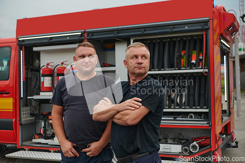 Image of A skilled and dedicated professional firefighting team proudly poses in front of their state of the art firetruck, showcasing their modern equipment and commitment to ensuring public safety.