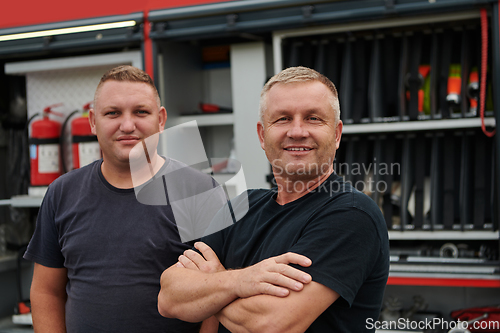 Image of A skilled and dedicated professional firefighting team proudly poses in front of their state of the art firetruck, showcasing their modern equipment and commitment to ensuring public safety.