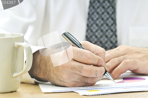 Image of Office worker writing on reports