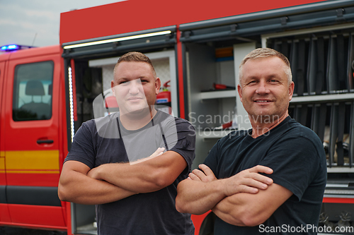 Image of A skilled and dedicated professional firefighting team proudly poses in front of their state of the art firetruck, showcasing their modern equipment and commitment to ensuring public safety.