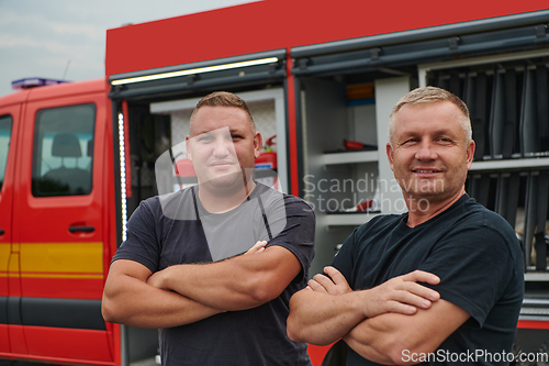 Image of A skilled and dedicated professional firefighting team proudly poses in front of their state of the art firetruck, showcasing their modern equipment and commitment to ensuring public safety.