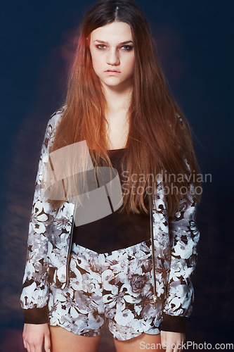 Image of Portrait, fashion and a serious young woman in studio on a dark background for clothing style. Hair, flare and intense with a confident redhead model in a trendy, casual or relaxed clothes outfit