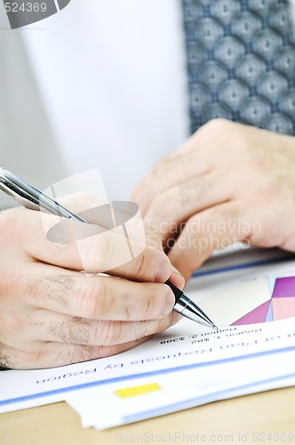 Image of Office worker writing on reports