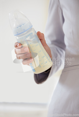 Image of Business, woman and baby bottle with mom in suit, working and balance a career with motherhood. Hand, closeup and mother with milk in container for child, care and management of family with a job