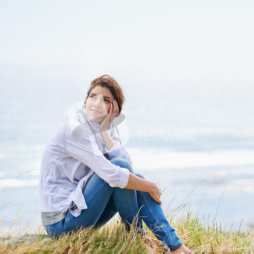 Image of Woman, thinking and relax at beach in nature with happiness, gratitude and peace on holiday or vacation. Mindfulness, mock up and person on hill at the ocean or sea with ideas for future or travel