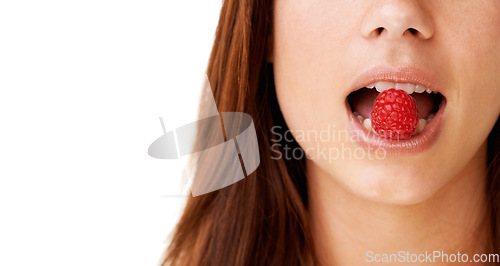 Image of Health, mouth and closeup of woman with raspberry in a studio for detox, vegan diet and fresh ingredient. Wellness, nutrition and face of young female model with organic fruit by white background.