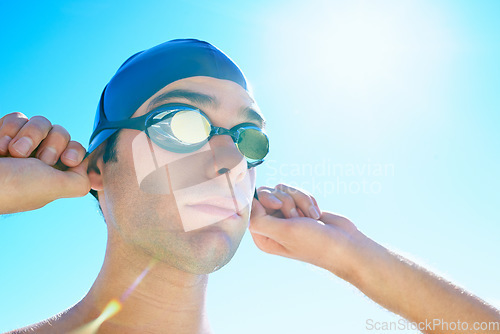 Image of Swimming, blue sky and face of sports man determined for exercise, outdoor workout or training routine. Swimwear, sunshine and person with cap, goggles and getting ready for active cardio practice