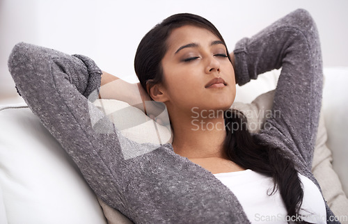 Image of Woman, peace and hands behind head on couch in living room for happiness, relaxing and easy lifestyle in a home. Person enjoy nap on sofa, calming weekend and self care of mental health with mindset