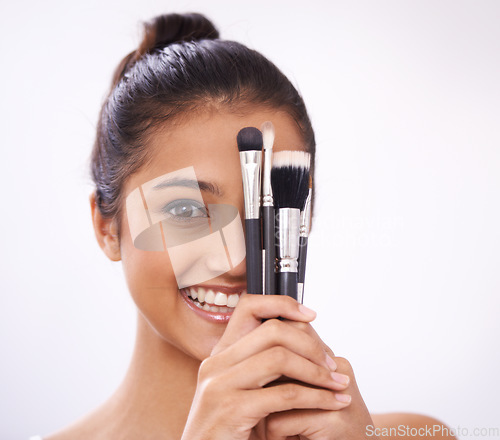 Image of Makeup, brushes and woman face with eyes cosmetics in studio for beauty and foundation on a white background. Young model, artist or person in portrait for skincare, eyeshadow or product for coverage