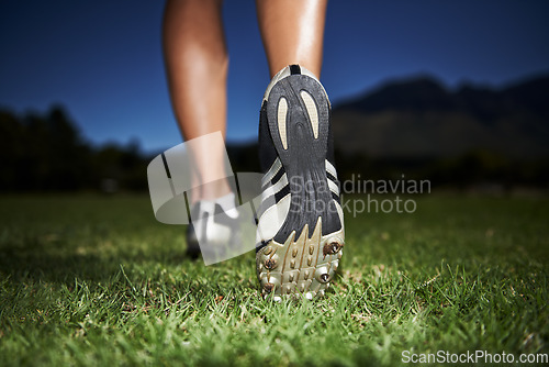 Image of Person, feet and fitness at night for workout, exercise or outdoor cardio in health and wellness in nature. Closeup of athlete legs, walking or running on green grass in the late evening for training