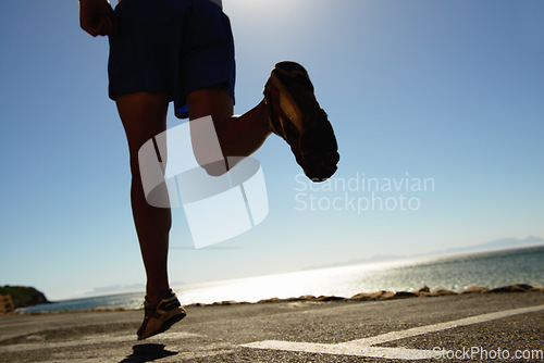 Image of Person, running and asphalt at beach for fitness, workout or outdoor cardio training on a sunny day. Closeup of athlete legs on run, sprint or race on road or street by the ocean coast on mockup