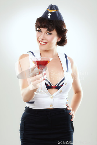 Image of Portrait, stewardess and happy woman with alcohol to drink in studio isolated on white background. Face, martini cocktail glass and air hostess with service, travel and vintage pin up girl on journey