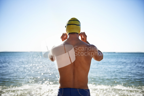 Image of Sports, sea and back of man for swimming exercise, workout or training routine in beach, nature or water. Wellness, active and person ready to start challenge, fitness contest or triathlon practice