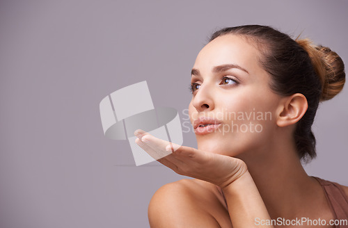 Image of Skincare, kiss and young woman in a studio with health, wellness and dermatology routine. Cosmetic, confident and female person with natural facial treatment and flirt gesture by gray background.