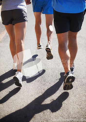 Image of People, fitness and legs running for workout, fitness or outdoor exercise together on asphalt or road. Closeup of athletic group or runners in sports training, teamwork or cardio on urban street