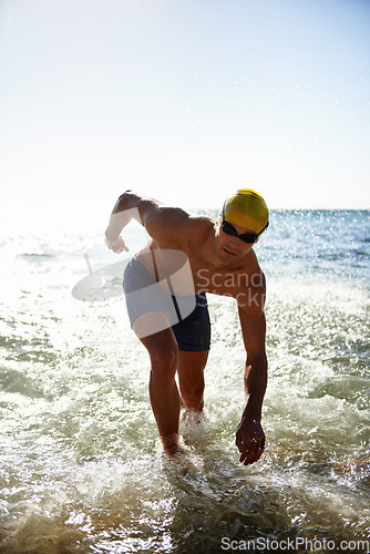 Image of Sports, sea waves and man for swimming exercise, workout or training routine in beach, nature or ocean. Mockup space, sky and person ready for cardio, fitness or triathlon practice in water splash