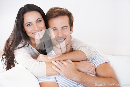 Image of Portrait, couple hug and love, relax on sofa with trust, marriage and happy at home for healthy relationship. People bonding, loyalty and connection with smile, partner and romance together at house