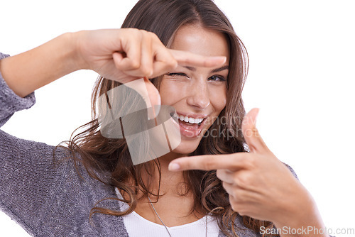 Image of Portrait, woman and wink with finger frame in studio to review profile picture on white background. Happy model, blink and check border with hands for photography, selfie and planning perspective