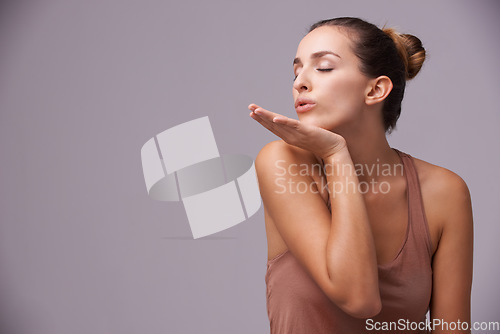 Image of Skincare, blow kiss and young woman in studio with health, wellness and dermatology routine. Cosmetic, confident and female person with natural facial treatment and flirt gesture by gray background.