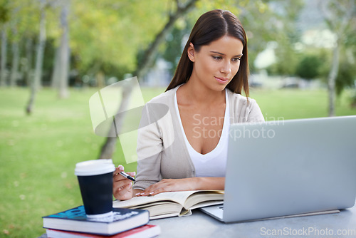 Image of Student, books and coffee with laptop in park, technology and education by table for studying. College, young woman and commitment with outdoor by tea, focus and writing notes with online connection