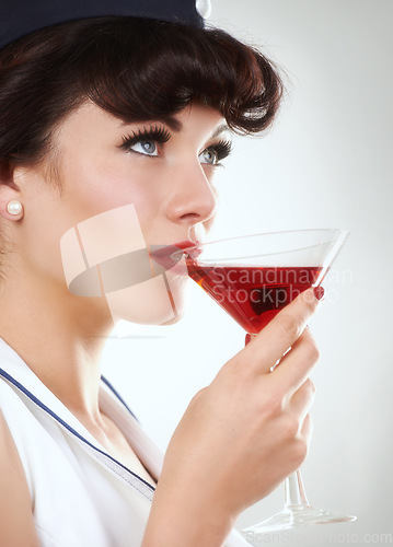 Image of Glass, flight attendant and woman drink alcohol in studio isolated on a white background. Martini, red cocktail and an air hostess enjoy beverage, vintage pin up girl or stewardess travel on journey