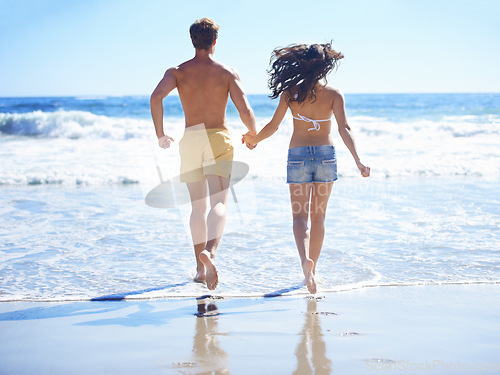 Image of Couple, holding hands and running on beach for holiday, swimming in summer and vacation by ocean. Back of people in bikini with love, valentines day and fun in sun and water or sea for anniversary