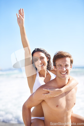 Image of Portrait, energy and piggyback with couple on beach together for holiday, vacation or romantic getaway. Smile, travel or love with happy young man and woman by ocean or sea for coastal adventure