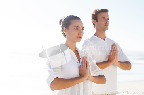 Image of Yoga, meditation and summer with couple on beach together for wellness, zen or holistic exercise. Travel, awareness or mindfulness with young man and woman by sea or ocean for balance and inner peace