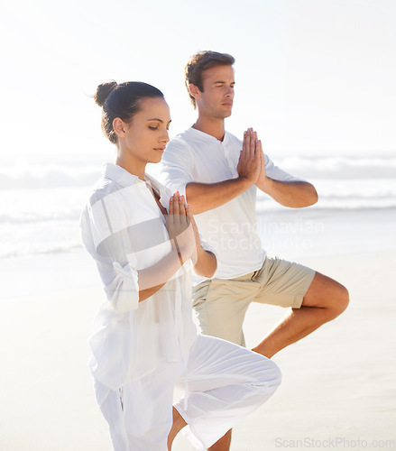 Image of Beach yoga, balance and relax couple meditate for spiritual peace, self care and outdoor wellness for chakra healing. Freedom, pilates partner and yogi meditation for calm, zen mindset or mindfulness