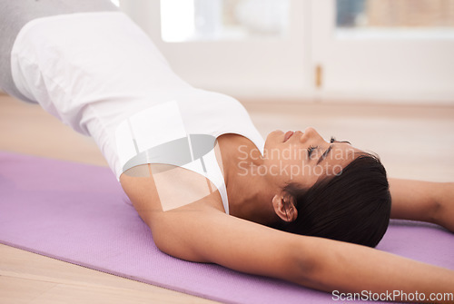 Image of Woman, yoga and stretching body for exercise, pilates or wellness in fitness or workout at home. Young and calm female person or yogi lying on floor mat in relax for zen, warm up or stretch at house