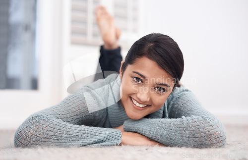 Image of Portrait of woman on carpet with smile, relax and weekend break to unwind in living room at house. Face of girl lying on floor of apartment to chill with happiness, peace and calm in lounge at home.