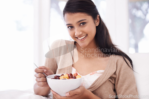 Image of Happy woman, portrait and fruit bowl for diet, nutrition or snack sitting on sofa at home. Face of young female person, nutritionist or vegan smile with healthy breakfast for vitamin c, salad or meal