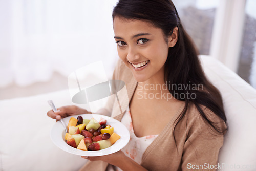 Image of Happy woman, portrait and bowl of fruit in diet, nutrition or healthy snack on sofa at home. Face of young female person, nutritionist or vegan smile and eating breakfast for vitamin c, salad or meal