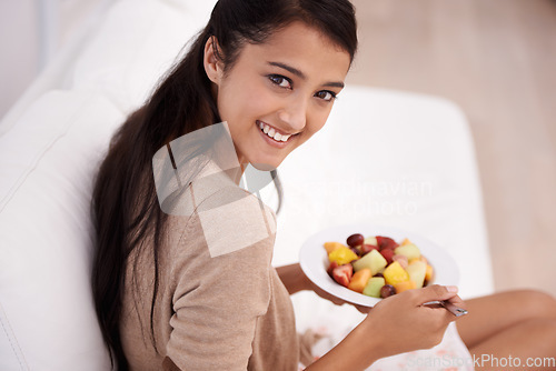 Image of Happy woman, portrait and bowl of fruit salad for diet, nutrition or healthy snack on sofa at home. Face of young female person, nutritionist or vegan smile and eating breakfast for vitamin c or meal